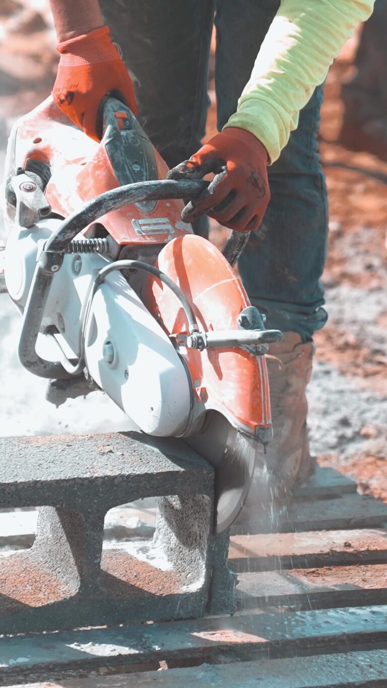 Worker cutting concrete block with a gas-powered saw