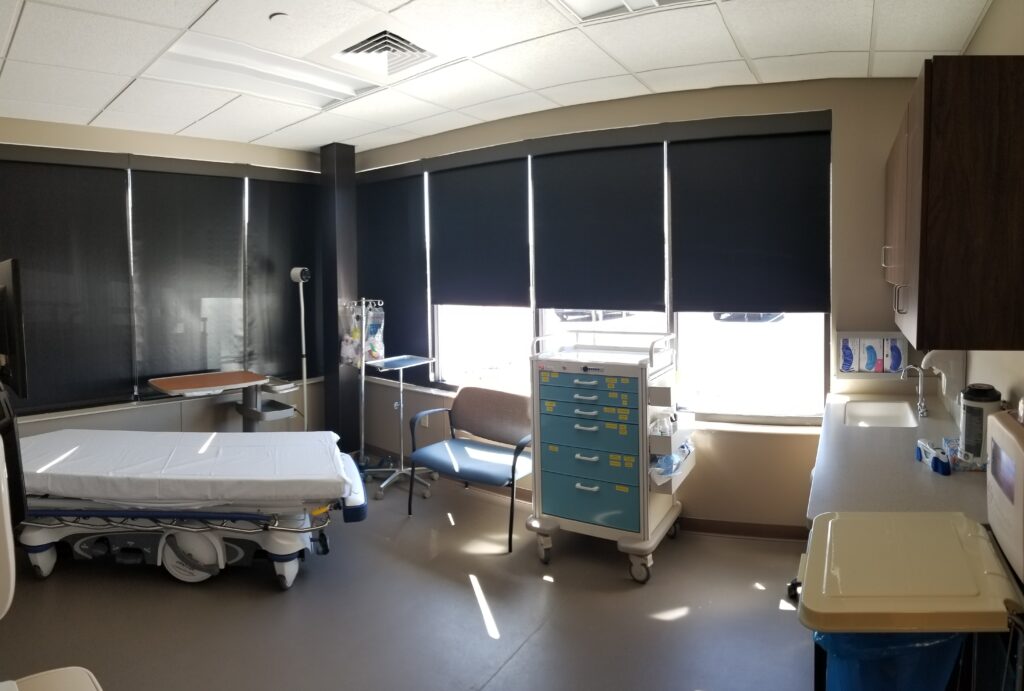 Patient treatment room with an exam bed and supply cart