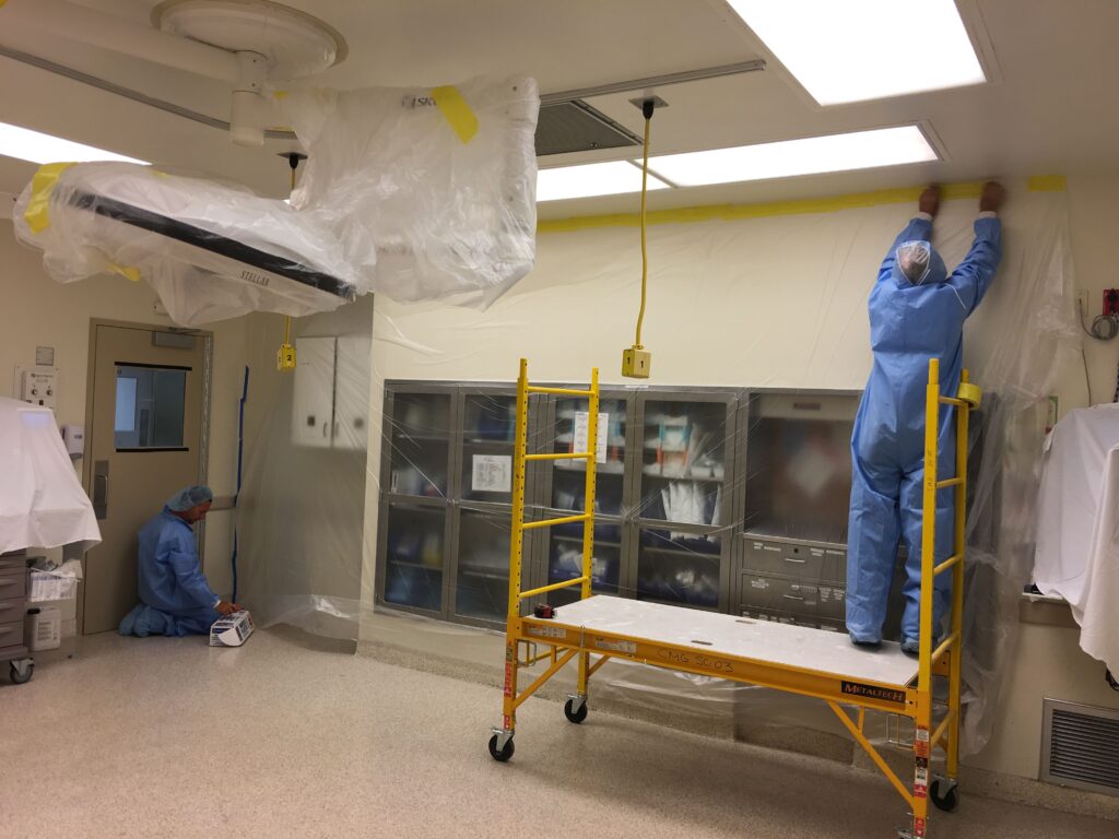 Crew in protective coveralls finishing a medical procedure room