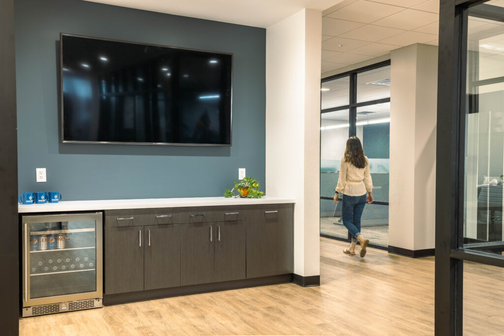 Office break area with cabinetry and a wall-mounted TV
