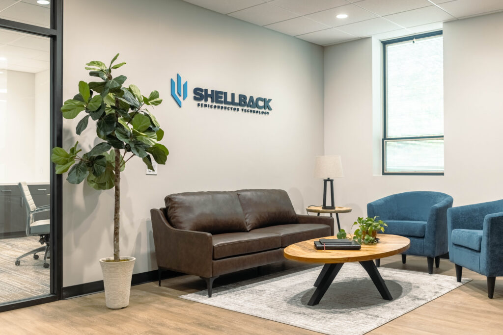 Office reception lounge with a leather sofa and blue chairs