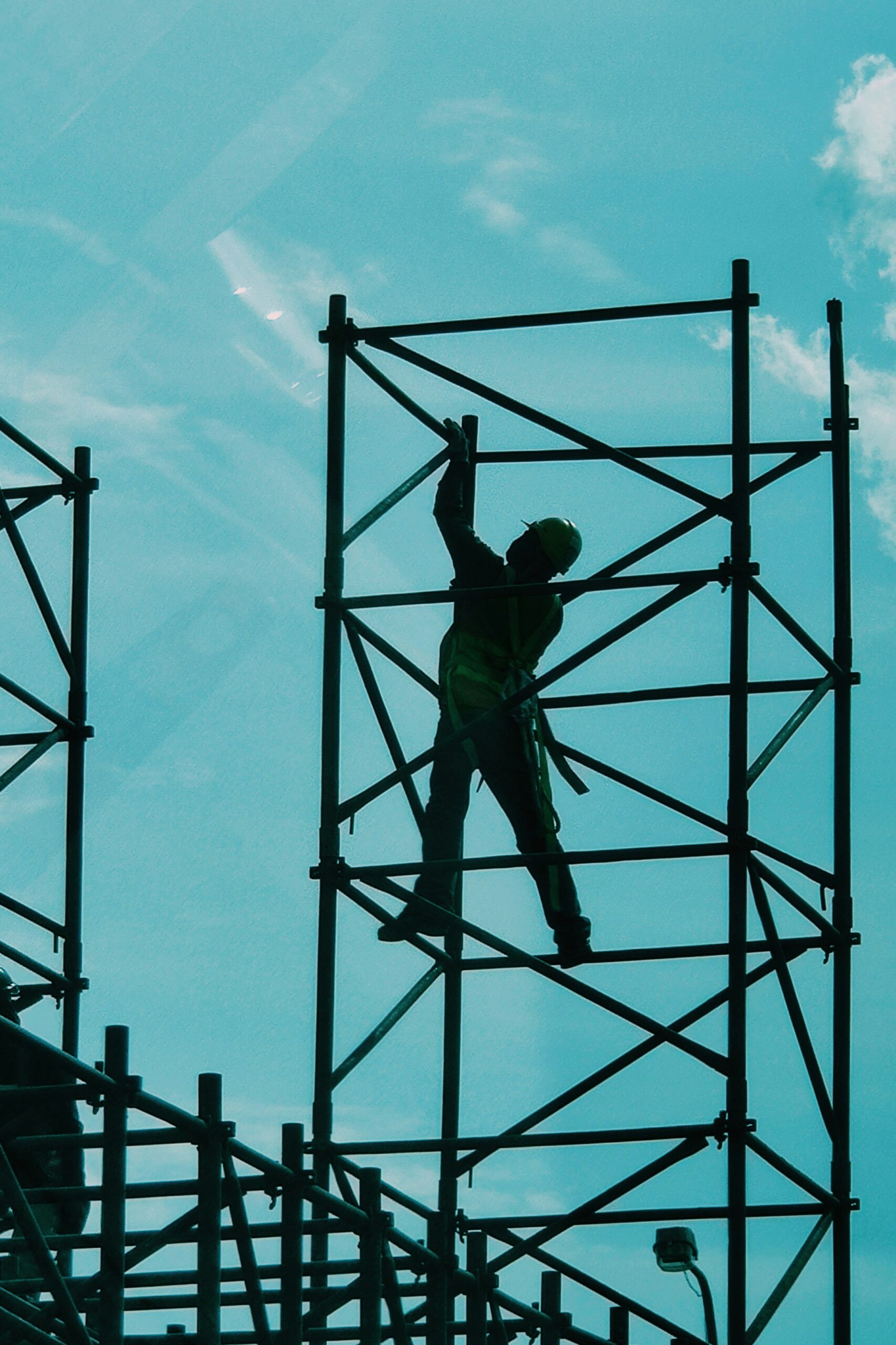 Worker on scaffolding against a blue sky